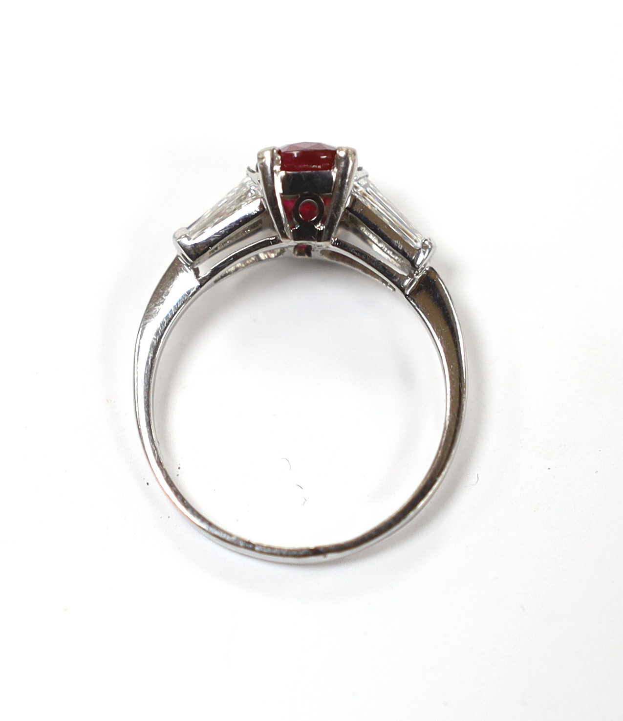 A white metal ruby ring with diamond set shoulders, housed in a Chow Tai Fook box gross weight 3.1grams